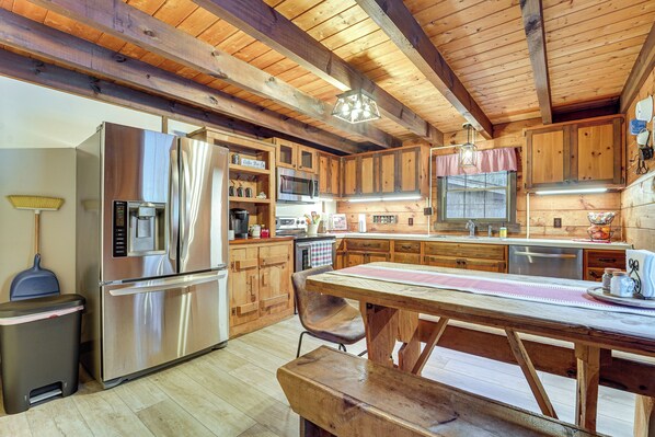 Una cocina moderna con armarios de madera, electrodomésticos de acero inoxidable y una mesa de comedor de madera.