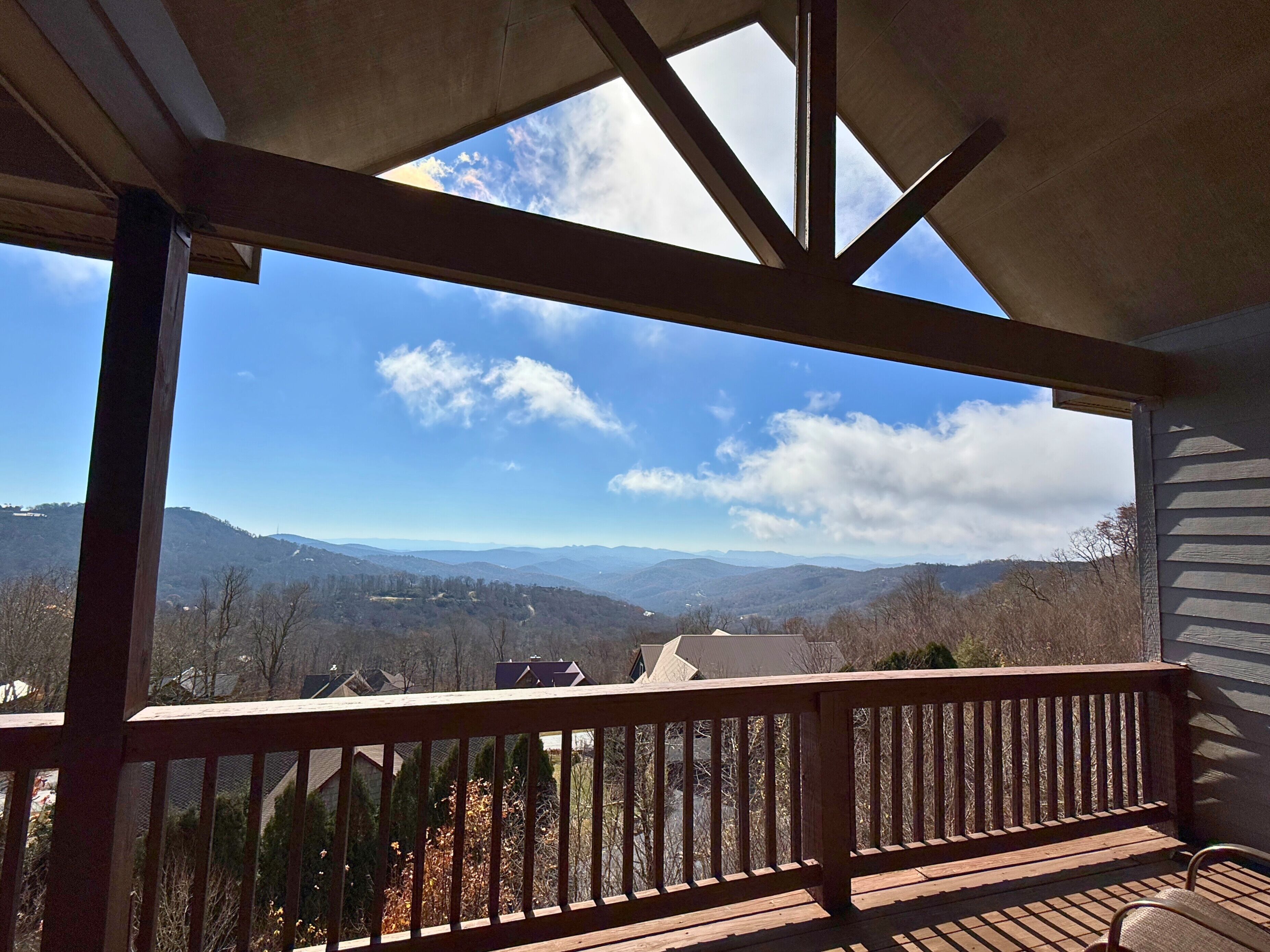 A wooden deck with a view of distant mountains and a clear sky.