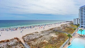 Une plage avec une piscine et, en arrière-plan, un immeuble de grande hauteur.