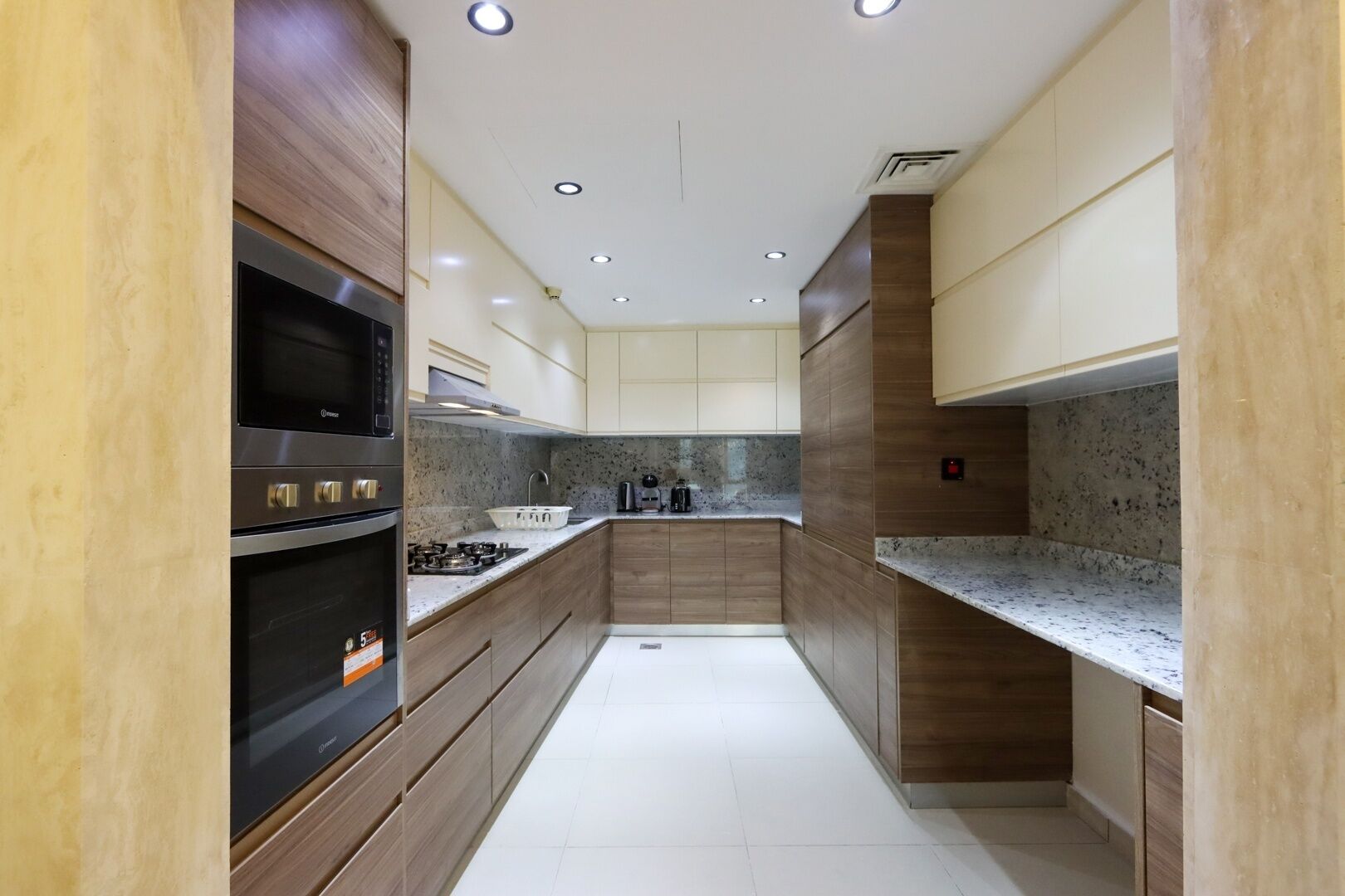 A modern kitchen with wooden cabinets, stainless steel appliances, and a granite countertop.