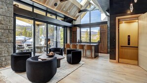 A modern interior with a stone wall, large windows, and a wooden ceiling.