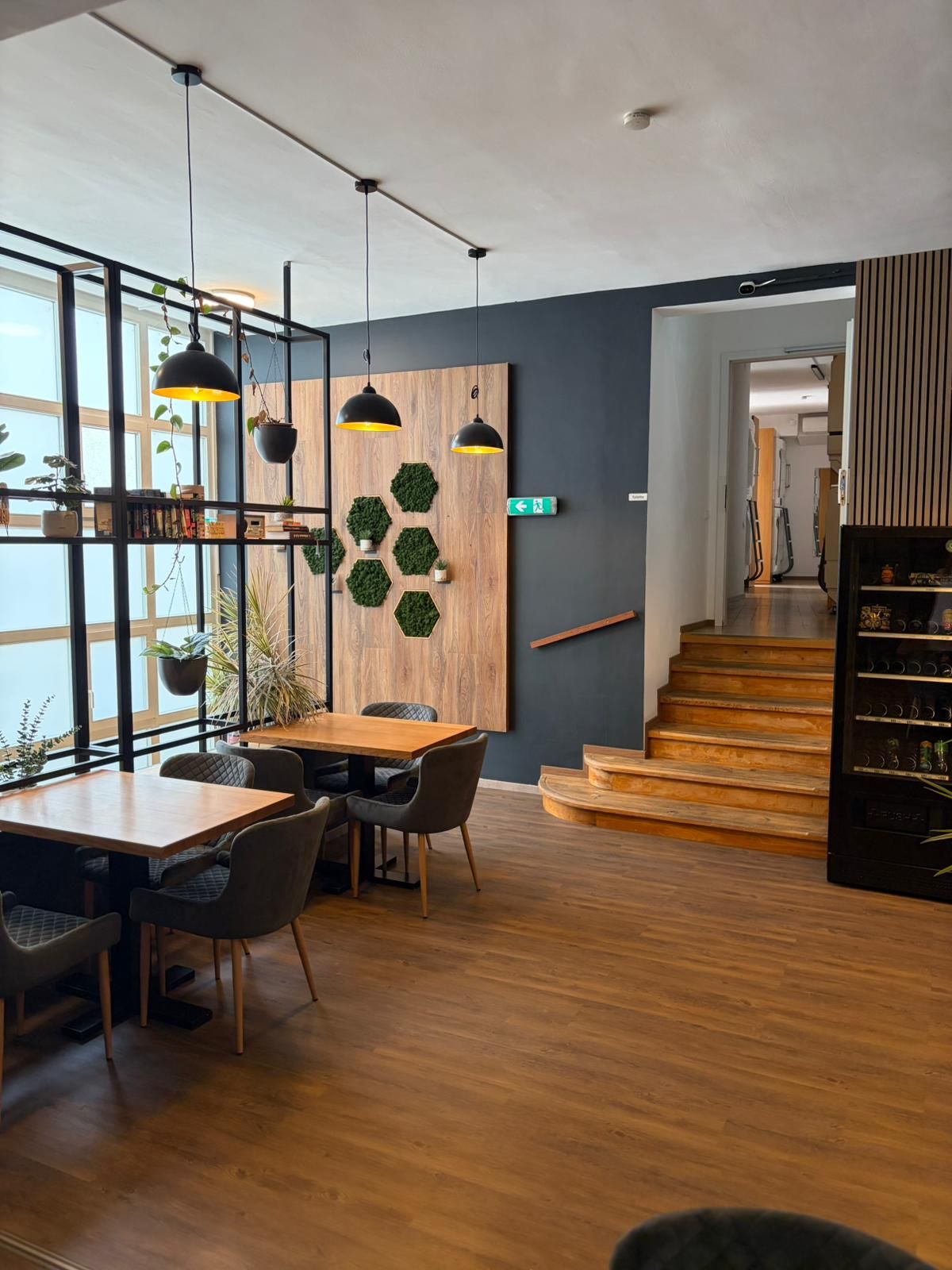 Un interior moderno con una mesa de comedor de madera, sillas e iluminación colgante.