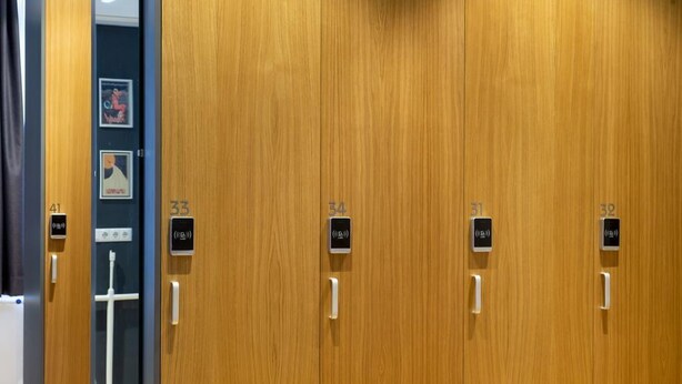 A row of wooden doors with numbered signs indicating room numbers 31, 33, 34, 41, and 10. - Spacehotel-Karlsruhe  (Karlsruhe)