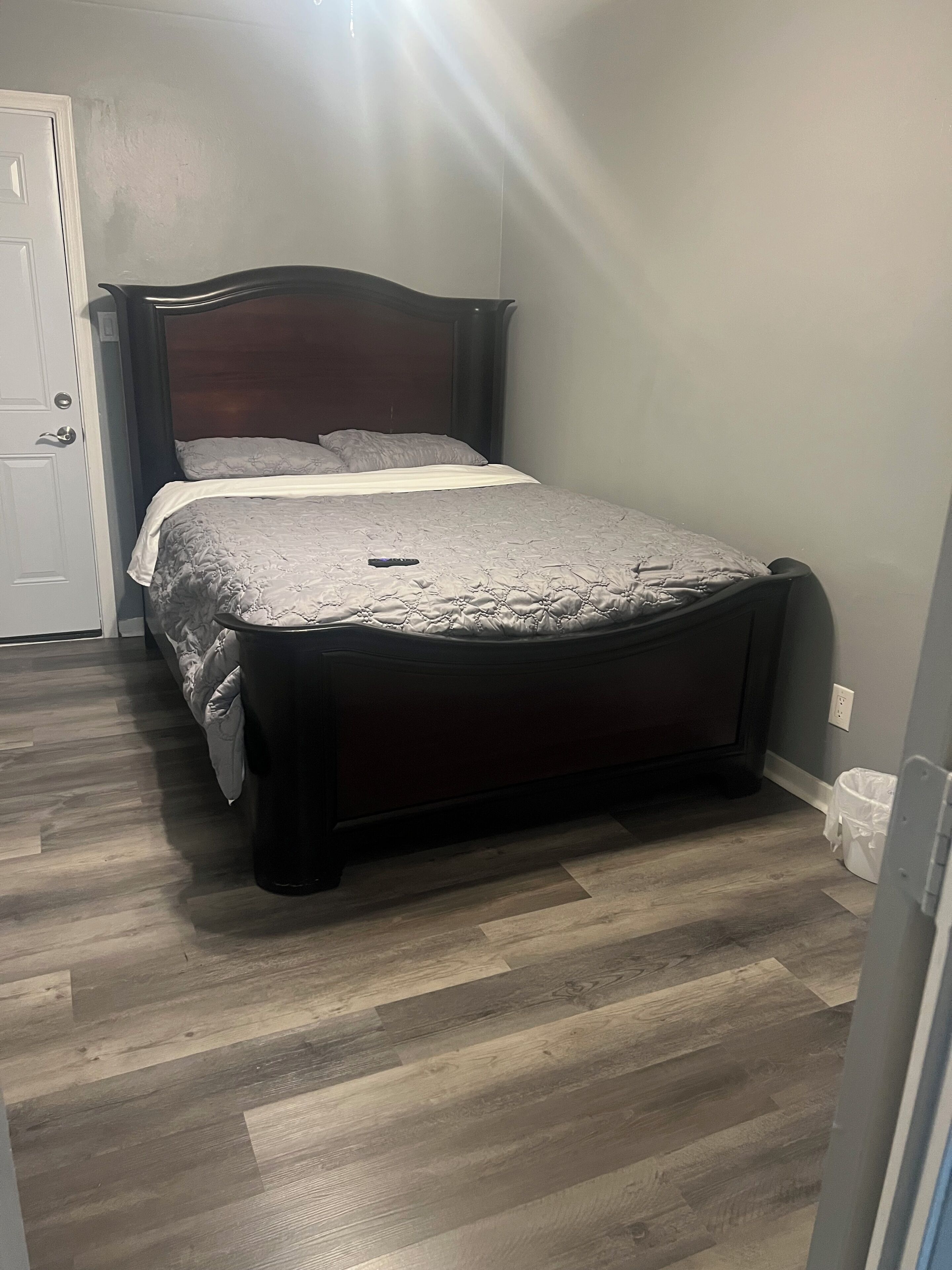 Une chambre à coucher avec un lit, une porte et une prise de courant.