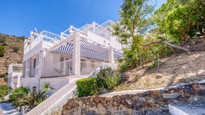 A modern building with a white exterior, multiple balconies, and a stone staircase leading up to the entrance. - Apartment in Roses Near Canyelles Beach (Roses)