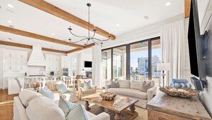 A spacious living area with a large sofa, coffee table, and a television on a wooden stand. - 1 HOUSE OFF THE BEACH! Private Pool, LSV/Golf Cart, Bikes, Games, Gym! Sleeps 22! (Santa Rosa Beach)