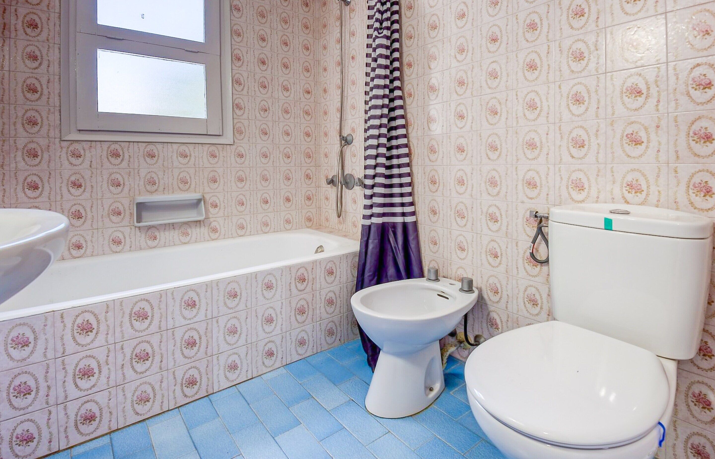 A bathroom with a bathtub, toilet, and bidet.