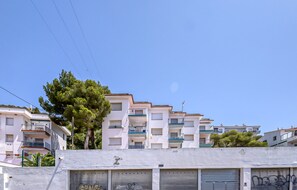 A row of multi-story residential buildings with balconies, a tree, and a clear sky. - Apartment With Scenic View (Roses)
