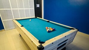 Een pooltafel met een witte laken, een witte poolbal en een pyramide van biljartballen.