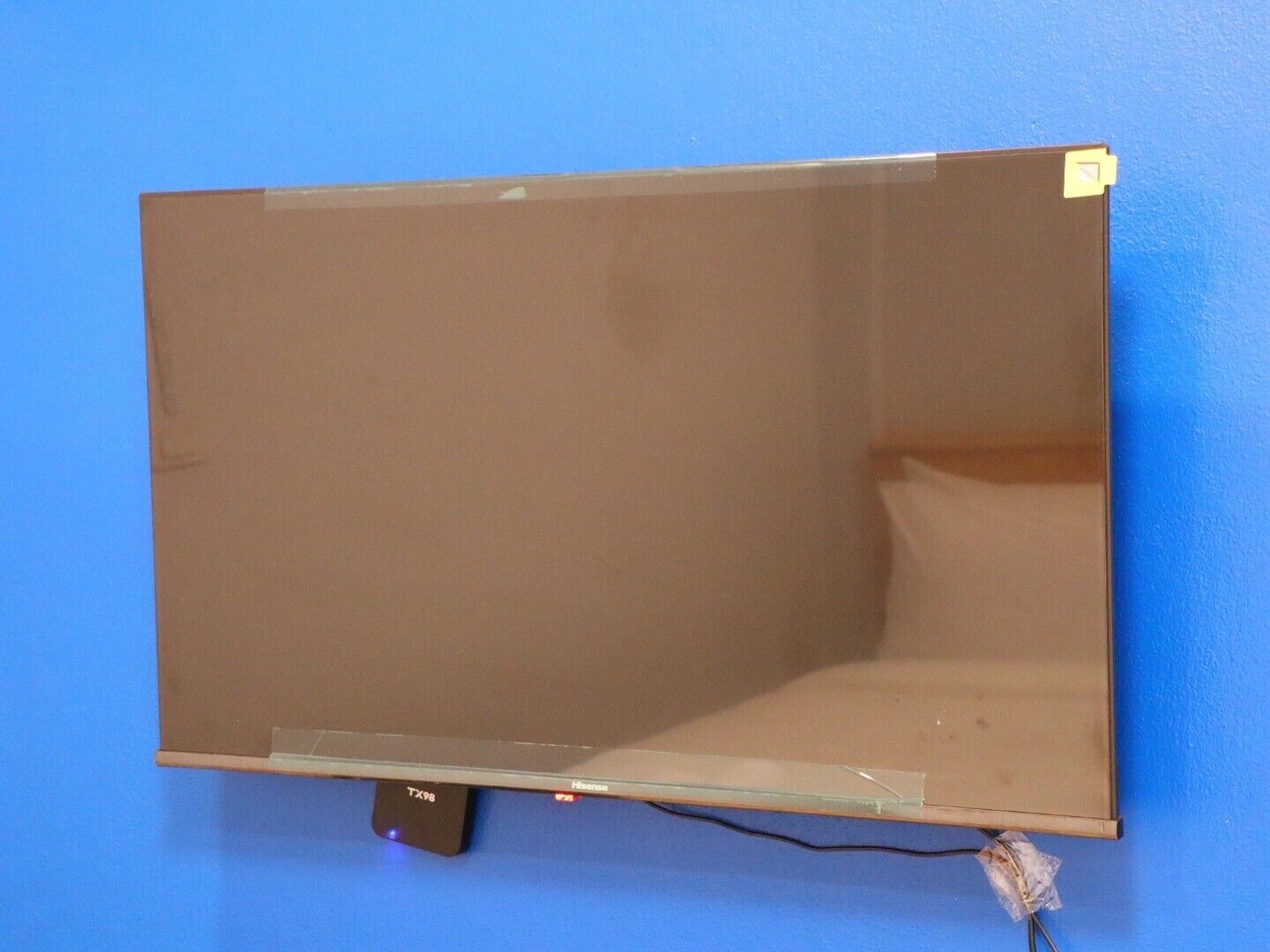 Televisor de pantalla plana montado en una pared azul.