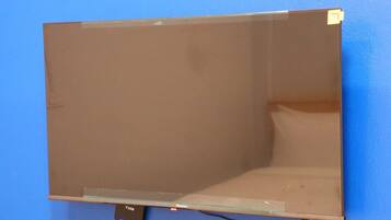 Televisor de pantalla plana montado en una pared azul.