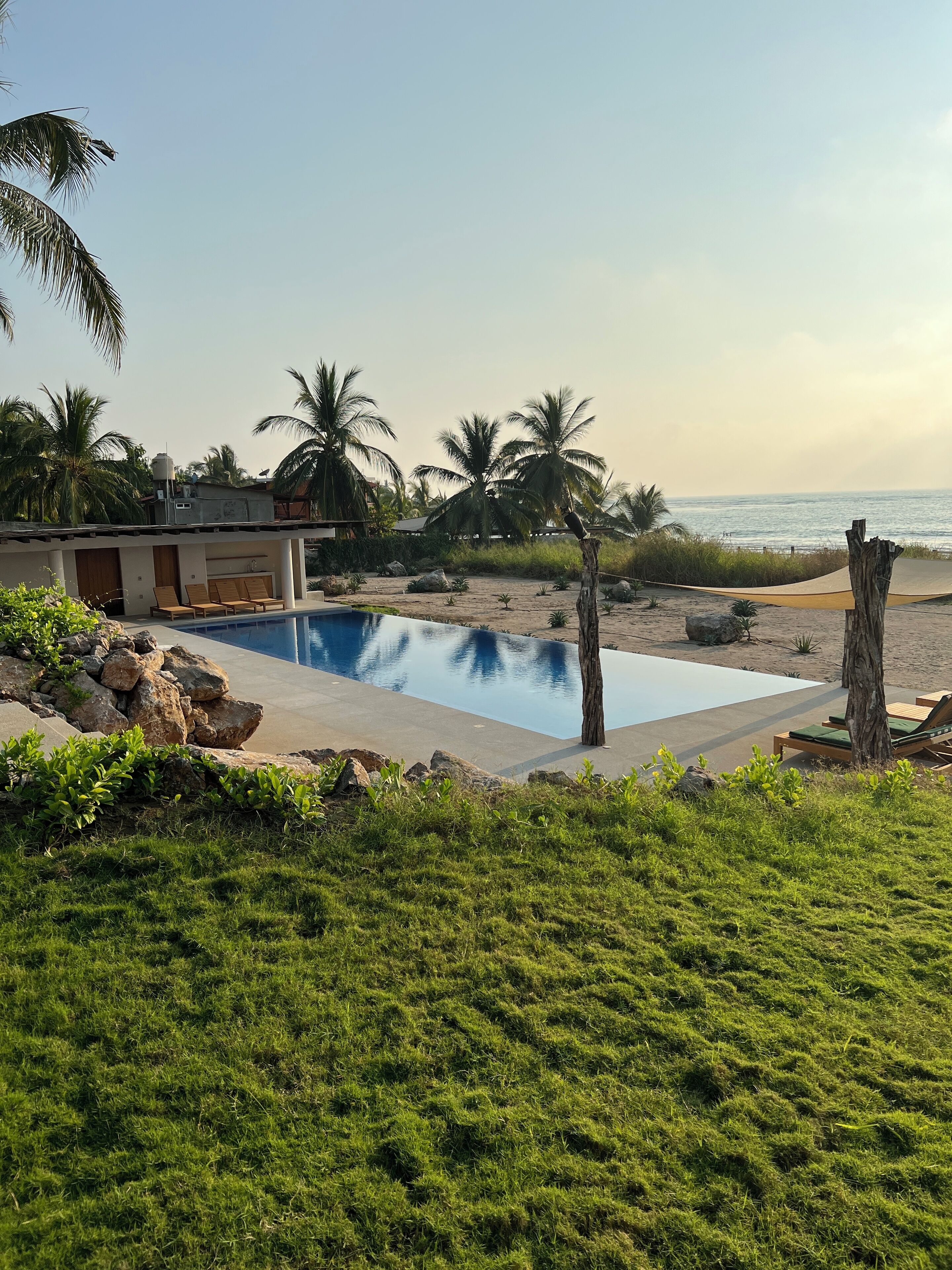 The pool has a pool house with a bathroom, kitchen, and a built-in sofa
