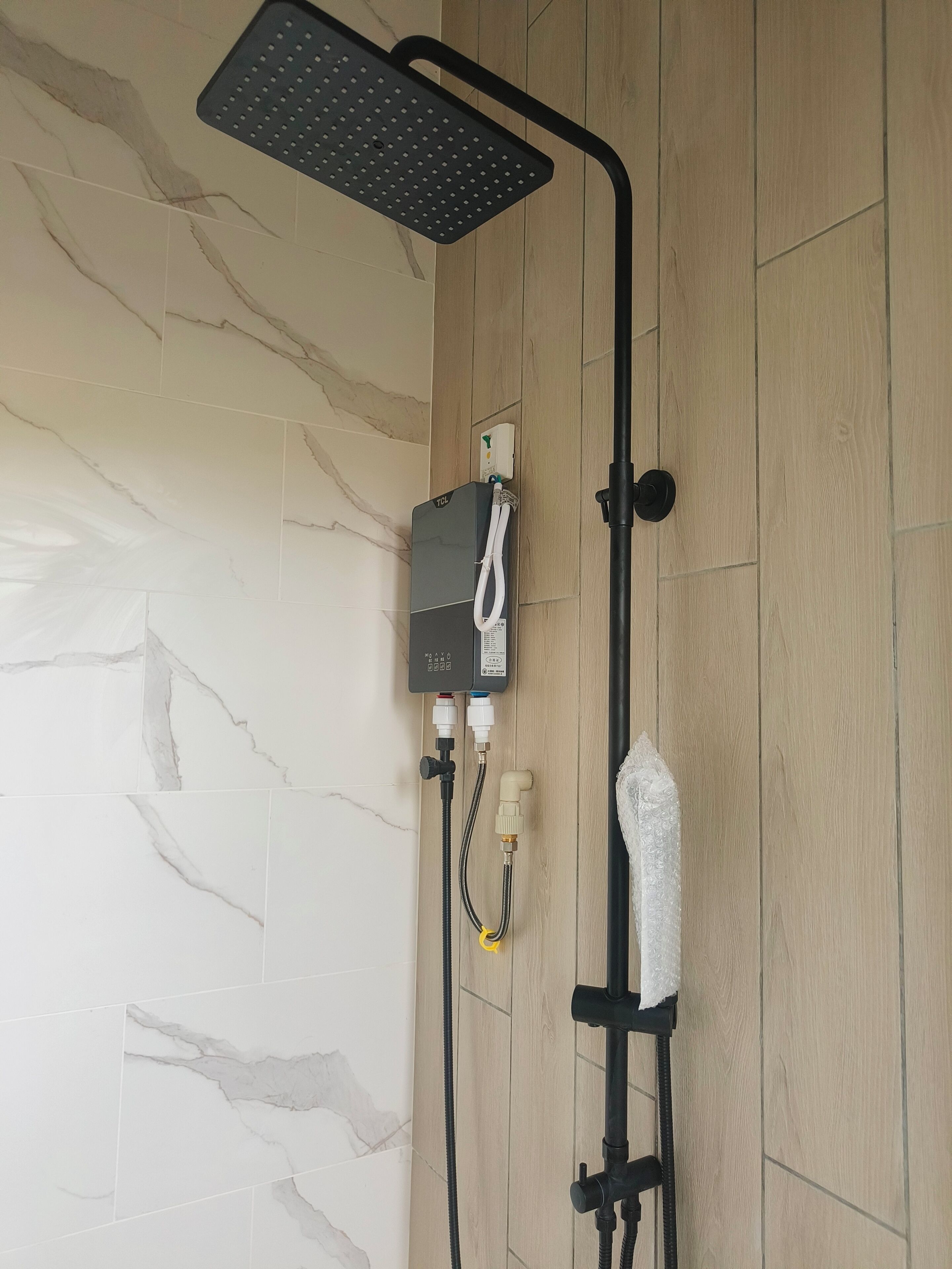 A shower with a handheld showerhead, a control unit, and a flexible hose.