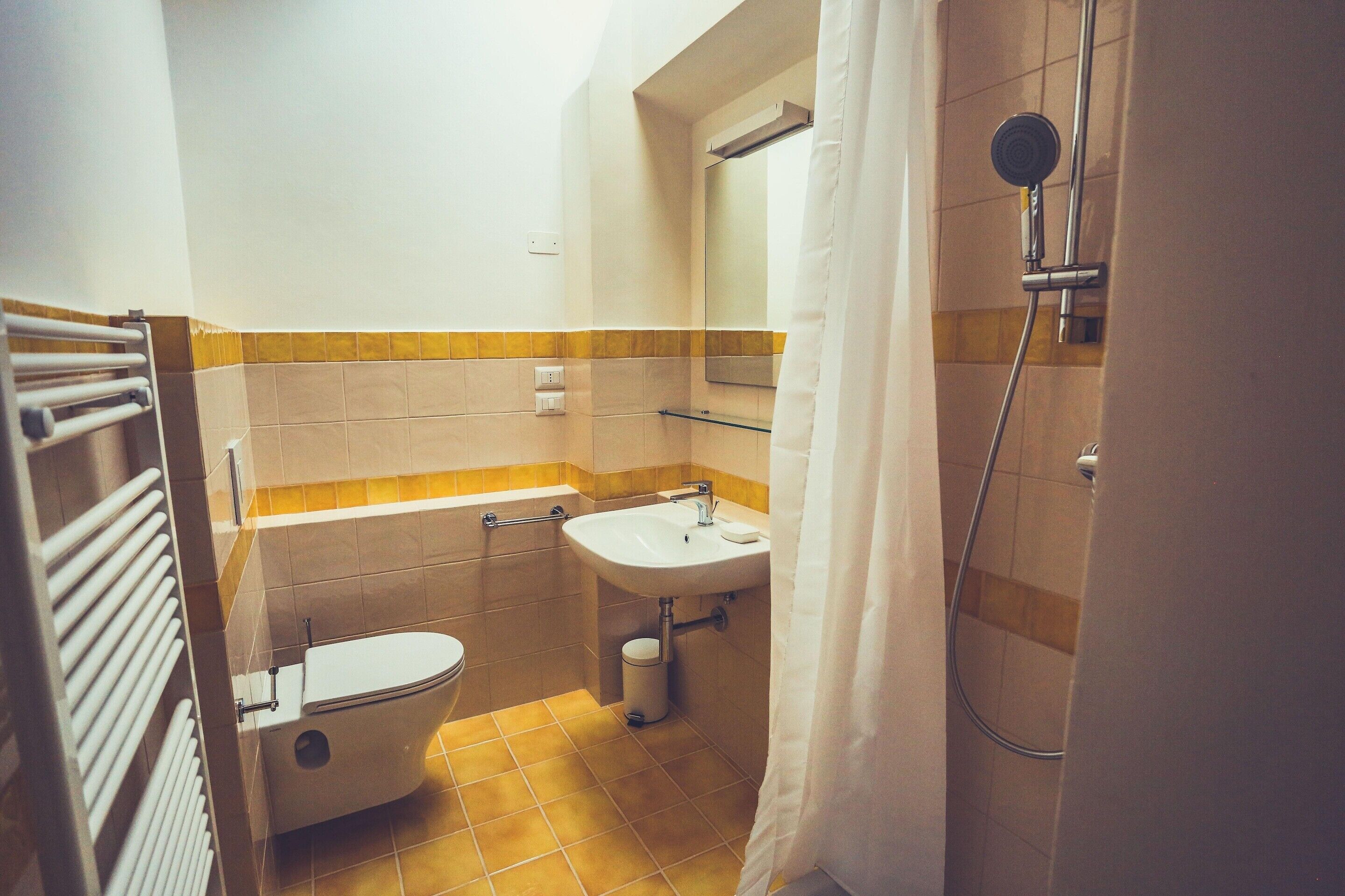 Une salle de bain avec des toilettes, un lavabo et une douche.