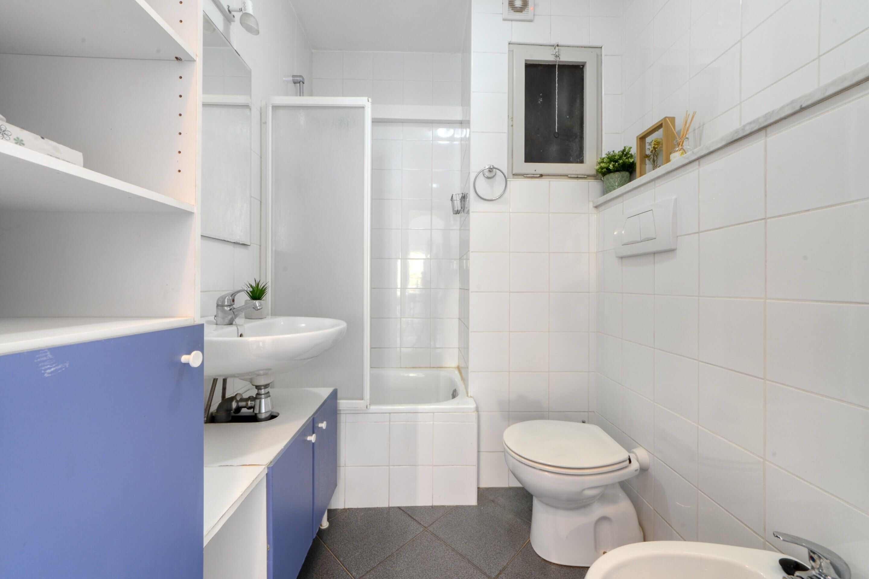 A modern bathroom with a bathtub, toilet, and sink.