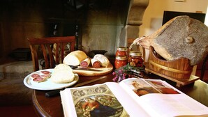 A dining table with bread, sliced meats, a jar of jam, and a book. - Farmhouse in Poppi With Pool & Gardens (Poppi)