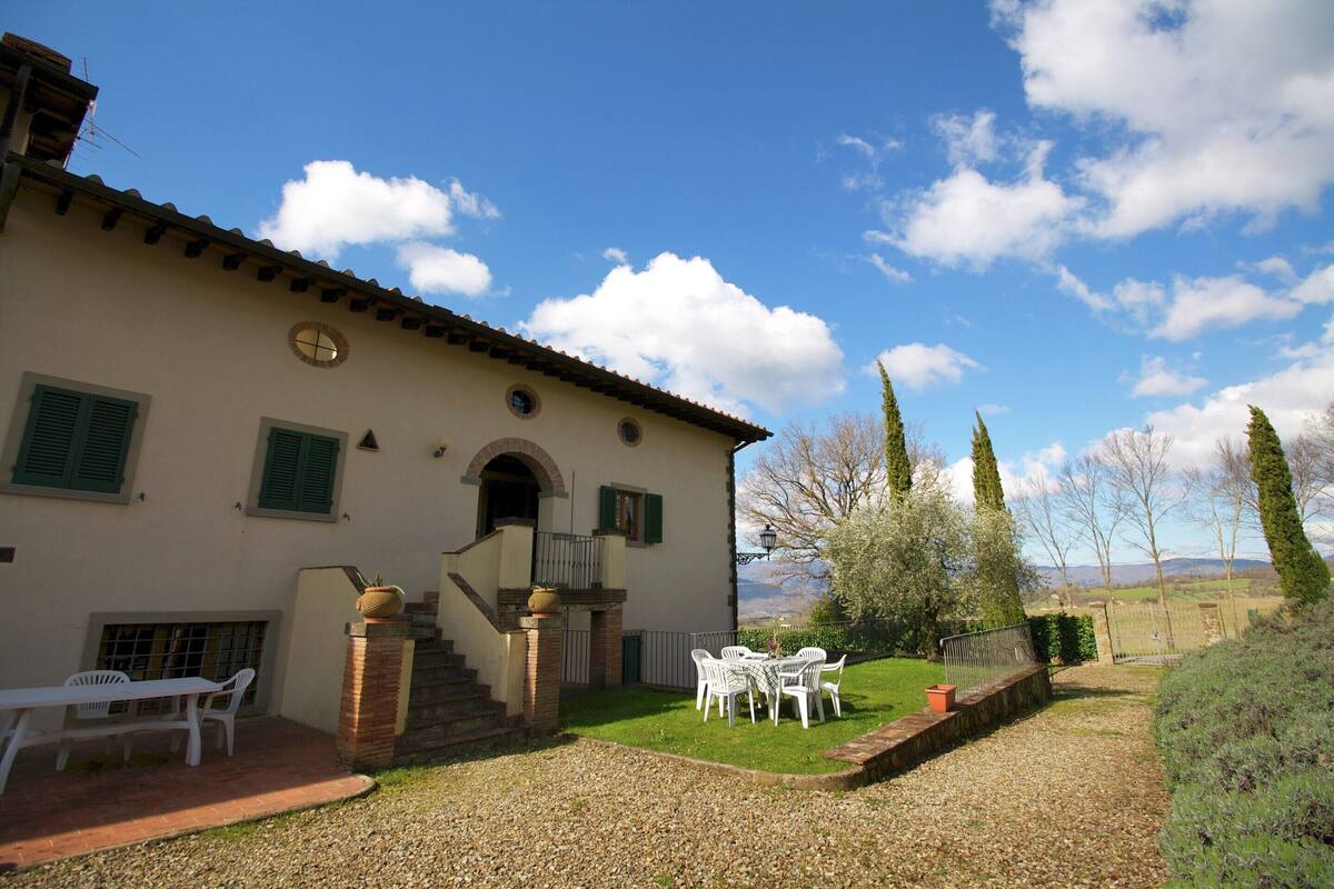A villa with a patio, outdoor seating, and a view of the countryside.