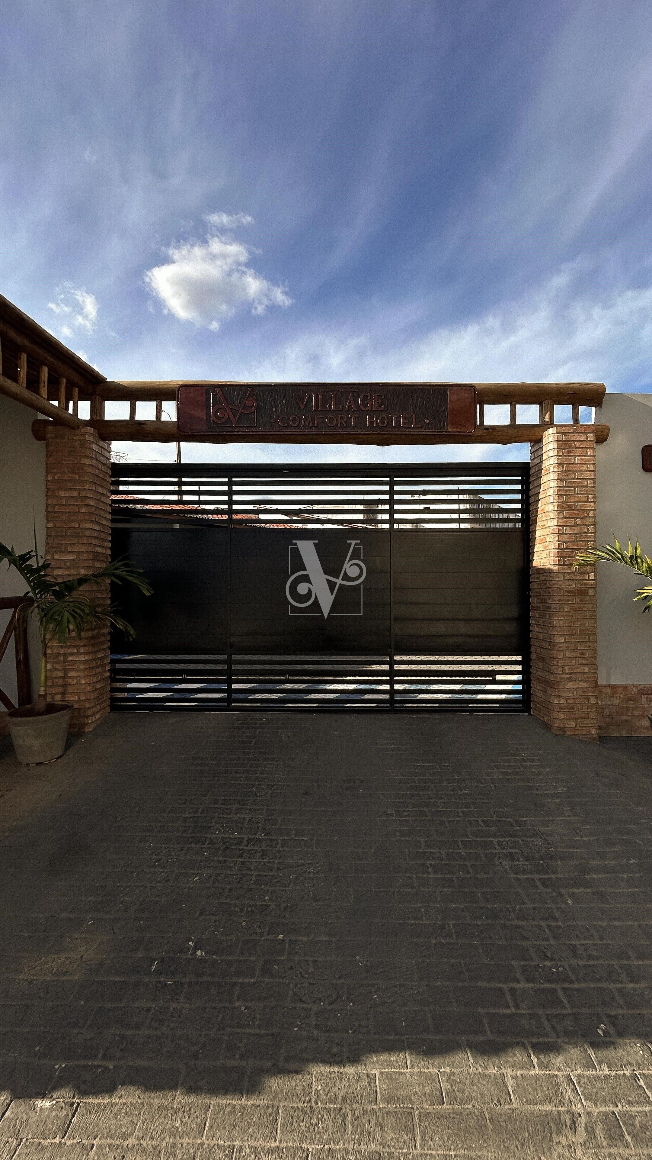 A gated entrance with a large metal gate and a logo.