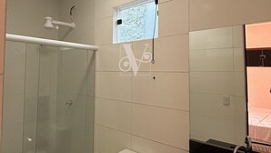 A modern bathroom with a glass shower enclosure, a toilet, a sink, and a mirror. - Village Comfort Hotel (Caninde de Sao Francisco)