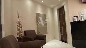 A modern lobby with a reception desk, two sofas, a decorative plant, and a marble floor. - Village Comfort Hotel (Caninde de Sao Francisco)