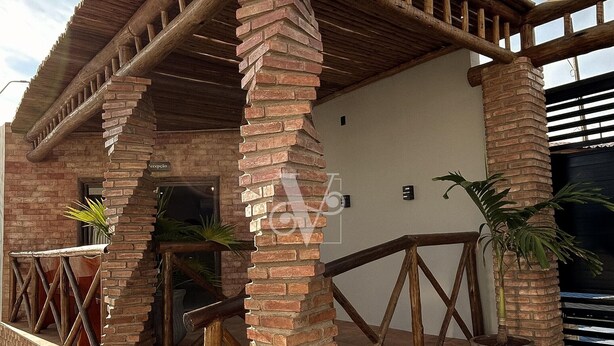 A rustic building with a brick chimney, wooden beams, and a metal gate. - Village Comfort Hotel (Caninde de Sao Francisco)