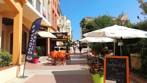 A street with outdoor seating, a restaurant named 'La Reserva', and a chalkboard menu. - Bright Flat Near Nature Park (Castello d'Empuries)