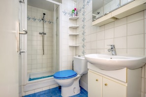 A bathroom with a shower, toilet, and sink.