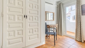 A room with a white door, a desk with a chair, a mirror, and a view through a glass door. - Rustic Chic w/ Mooring Spot (Castello d'Empuries)