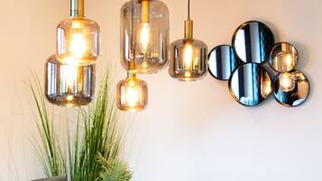 Un espace repas comprenant une table en bois, des chaises et des lampes suspendues.