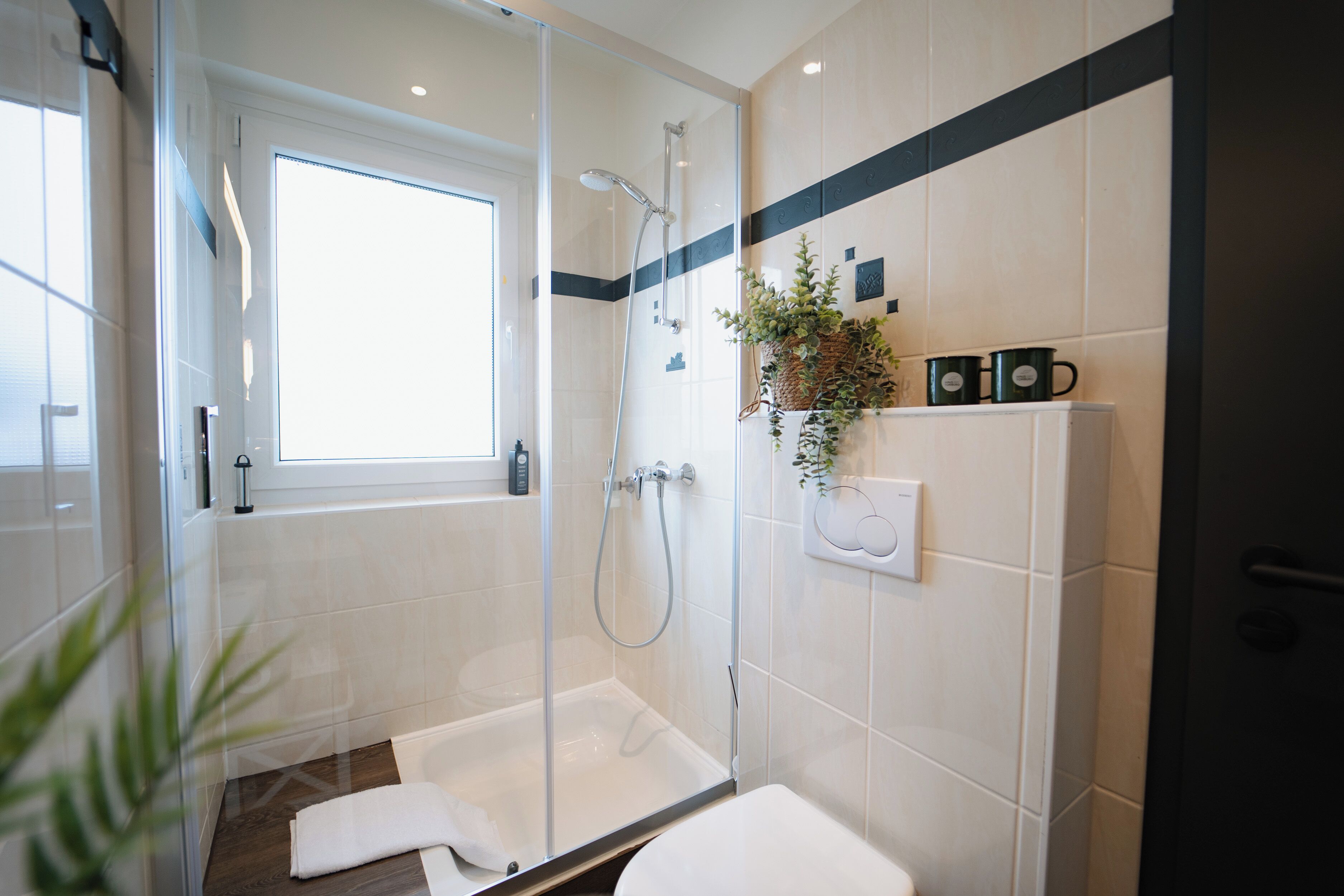 Un baño moderno con ducha de vidrio, bañera blanca y retrete.