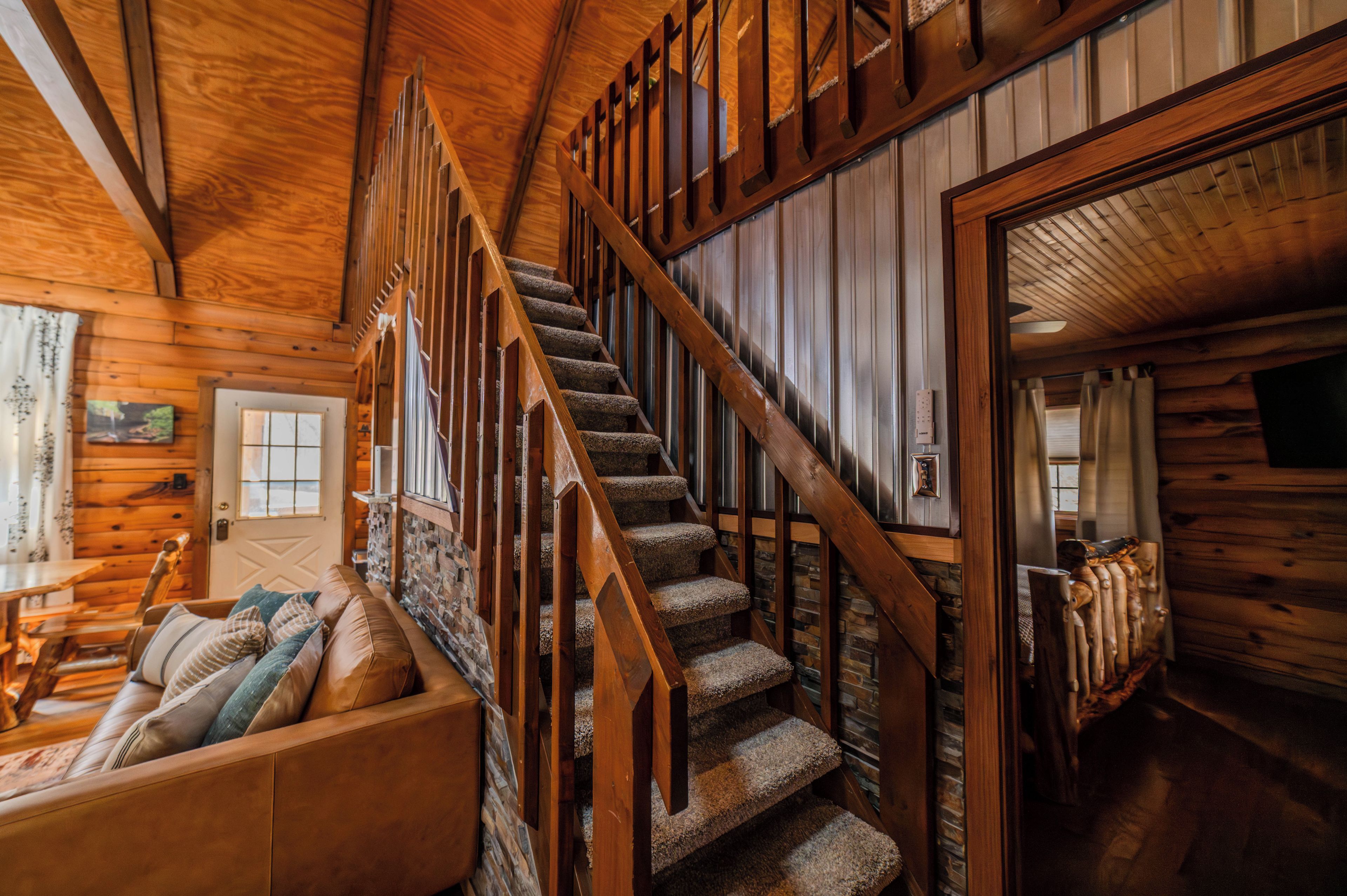 A wooden staircase with a wooden railing leading to a second floor.