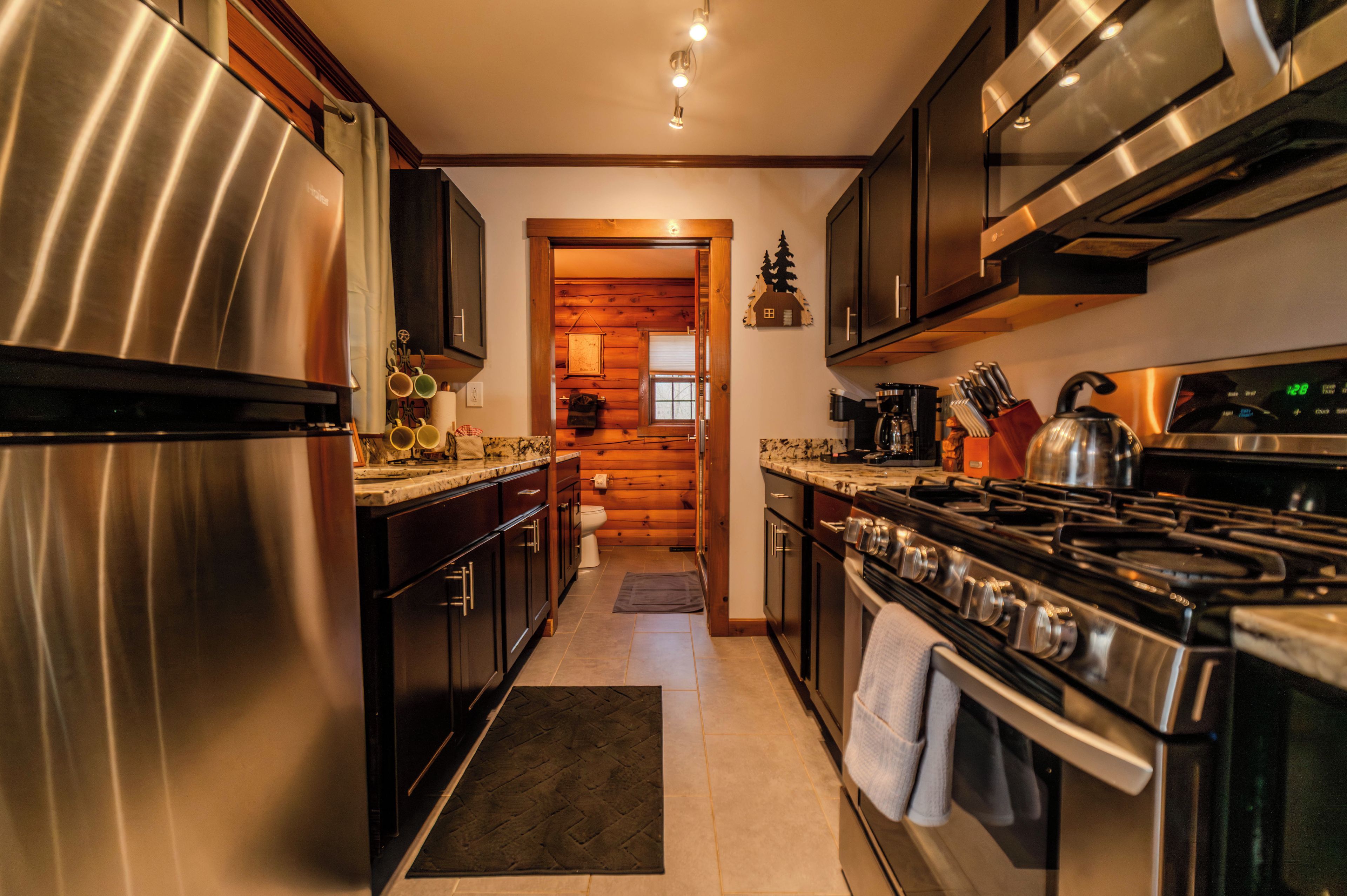 A modern kitchen with stainless steel appliances, wooden cabinets, and a central island.