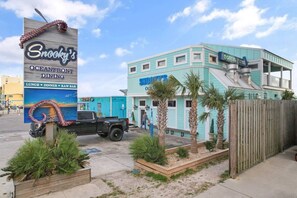 Een restaurant met een bord, een vrachtwagen en een gebouw met een blauwe gevel.