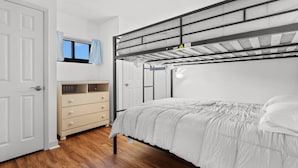 A bunk bed with a headboard, a bedside table, a dresser, and a window with curtains. - Oceanfront- Pools- Hot Tub- Grill- Near Shops- Gym (North Myrtle Beach)