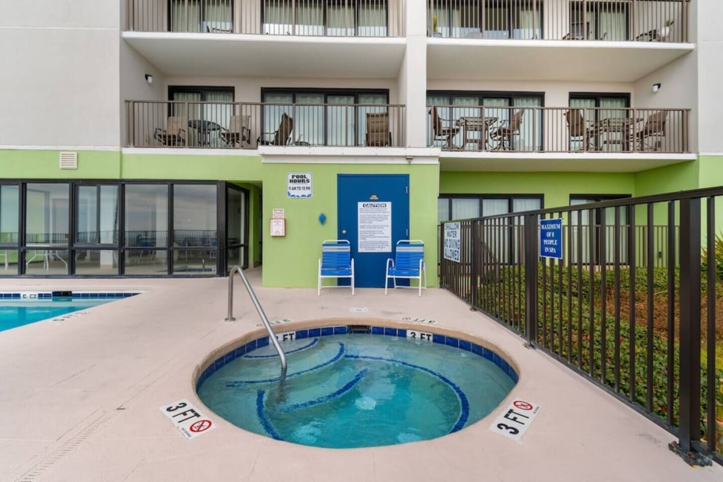 Une piscine dont la profondeur est indiquée à 3 pieds, avec une chaise au bord du bassin et un panneau indiquant que le nombre maximal de personnes autorisées dans le spa est de 1.