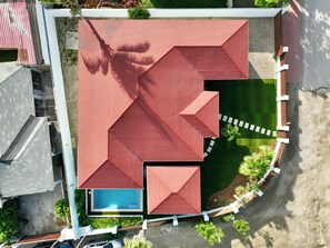 An aerial view of a building with a red roof, a swimming pool, and a landscaped garden. - Backyard Bliss: 4BR Pool Home, 4Min to Eagle Beach (Noord)