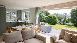 Une cuisine moderne avec un coin repas, une grande fenêtre et une vue sur un jardin.