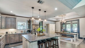 A spacious kitchen with a large island, pendant lights, and a view of the outdoors. - Refined Lake Retreat on Lake Fork in Emory, TX, fishing, kayaking, antiquing (Emory)