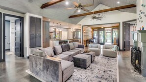 A spacious living area with a large sectional sofa, ottomans, and a patterned rug. - Refined Lake Retreat on Lake Fork in Emory, TX, fishing, kayaking, antiquing (Emory)