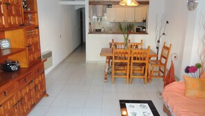 A compact living space with a dining area, kitchenette, and a sofa. - Cozy Apartment With Furniture (Roses)