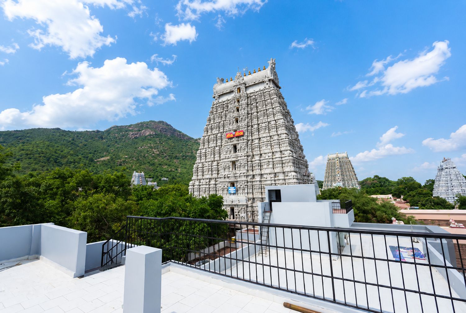 A temple with intricate carvings, a clear sky, and a mountainous backdrop.