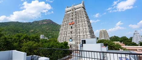 A temple with intricate carvings, a clear sky, and a mountainous backdrop.