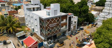 A multi-story building with a prominent sign reading 'ARUDHIRA RESIDENCY.'