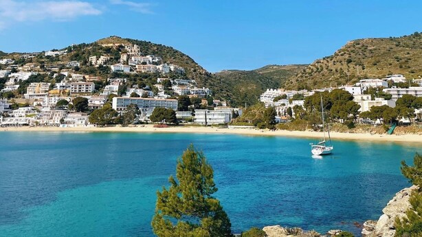 A coastal town with buildings on a hillside overlooking a clear blue sea. - Tranquil Holiday Home in Empuriabrava (Castello d'Empuries)