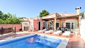 A swimming pool with lounge chairs and a covered patio area. - Tranquil Holiday Home in Empuriabrava (Castello d'Empuries)
