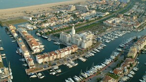 An aerial view of a marina with numerous boats docked, surrounded by residential buildings and a prominent tower structure. - Tranquil Holiday Home in Empuriabrava (Castello d'Empuries)