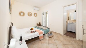 Ein Schlafzimmer mit Bett, Nachttisch und angrenzendem Badezimmer.