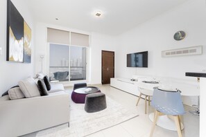 Una sala de estar moderna con un sofá, reposapiés y un comedor con mesa y sillas.