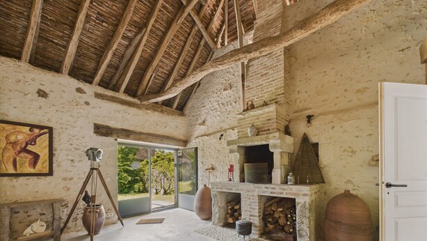 A rustic interior with a high wooden ceiling, a fireplace, and a large window. - Old farmhouse renovated for 6 into 2 flats (Fossemagne)