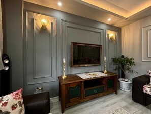 A living room with a large mirror, wooden console table, and two green drawers. - Garden House Villa (Trabzon)